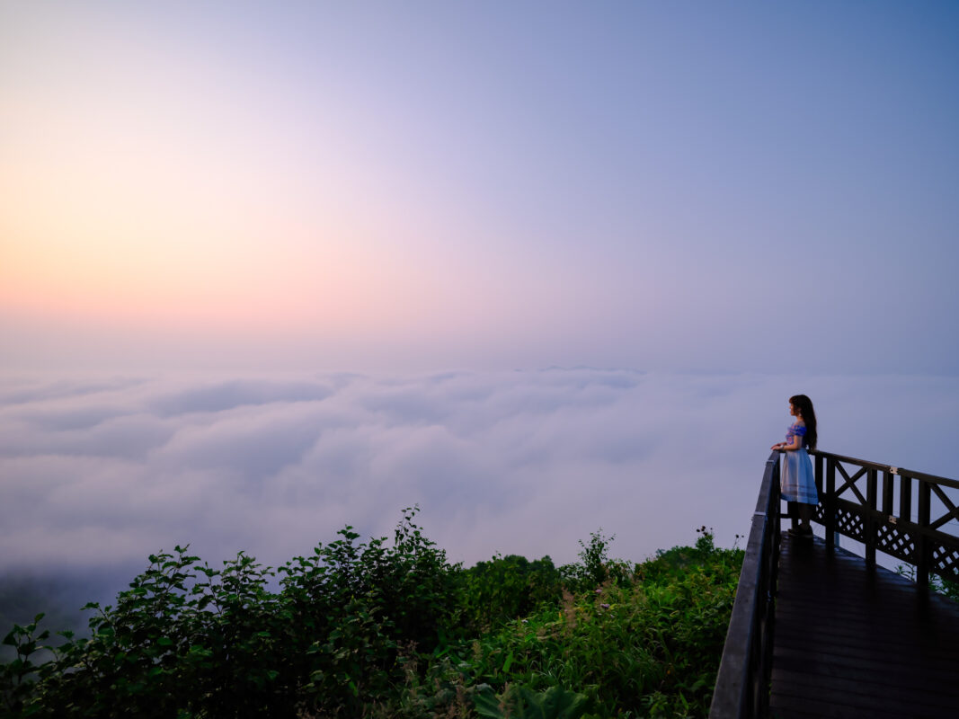 Visitor on Unkai Terrace observation deck overlooking sea of clouds at sunrise
