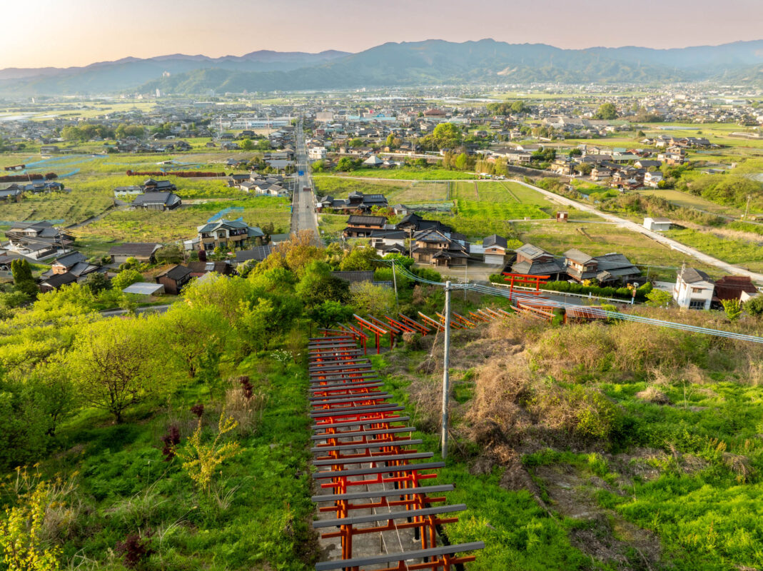 Vermilion torii gate path descending hillside at Ukiha Inari Shrine, Japan