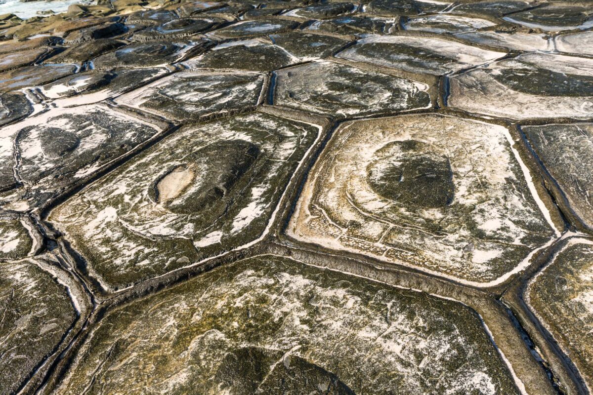 Aerial view of polygonal rock formations and cracks on Kumejima Island, Japan