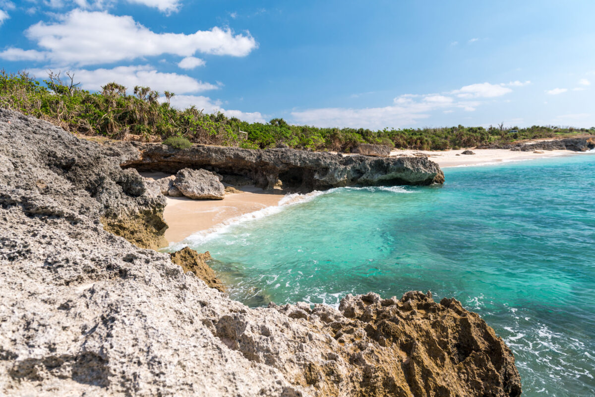 Turquoise cove with sandy beach and limestone cliffs on Miyako Island, Japan