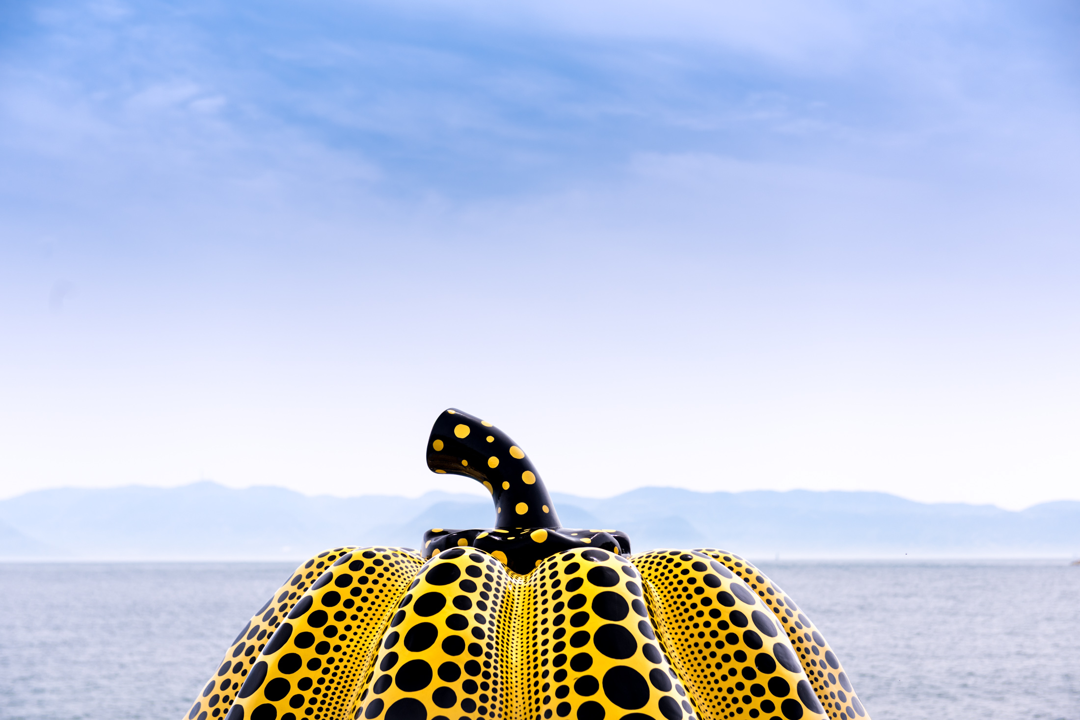 Yellow polka dot pumpkin sculpture on Naoshima Island overlooking the Seto Inland Sea