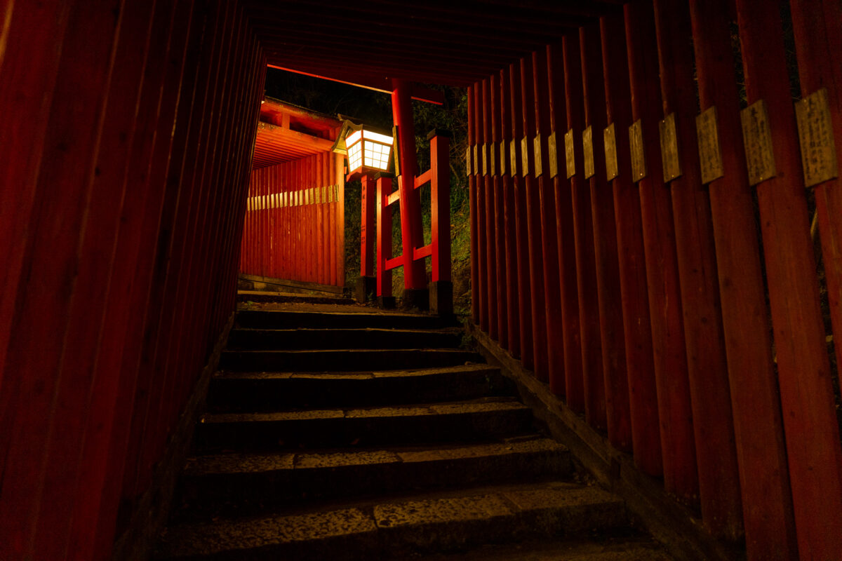 Vermilion torii staircase at Taikodani Inari Shrine, Japan, lit by a lantern.