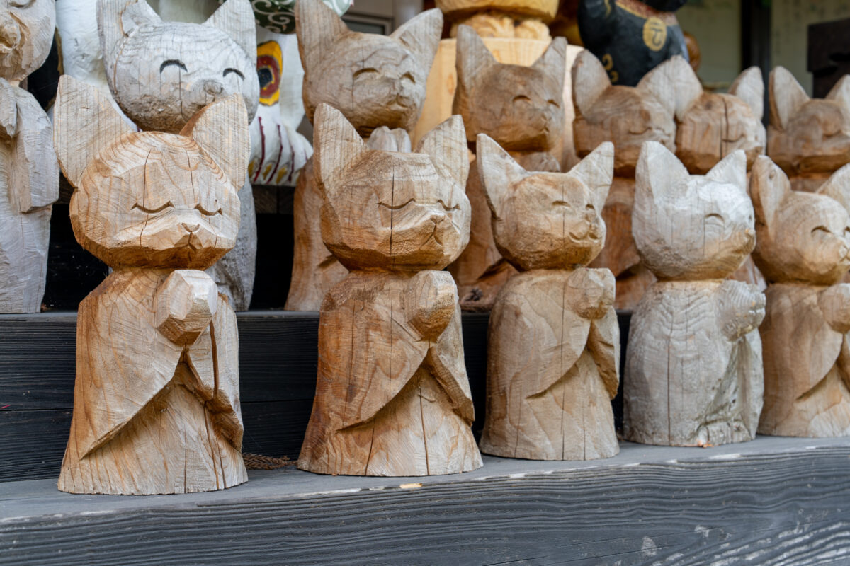 Hand-carved wooden fox statues lined on shelves inside Unrin-ji Temple, Japan.