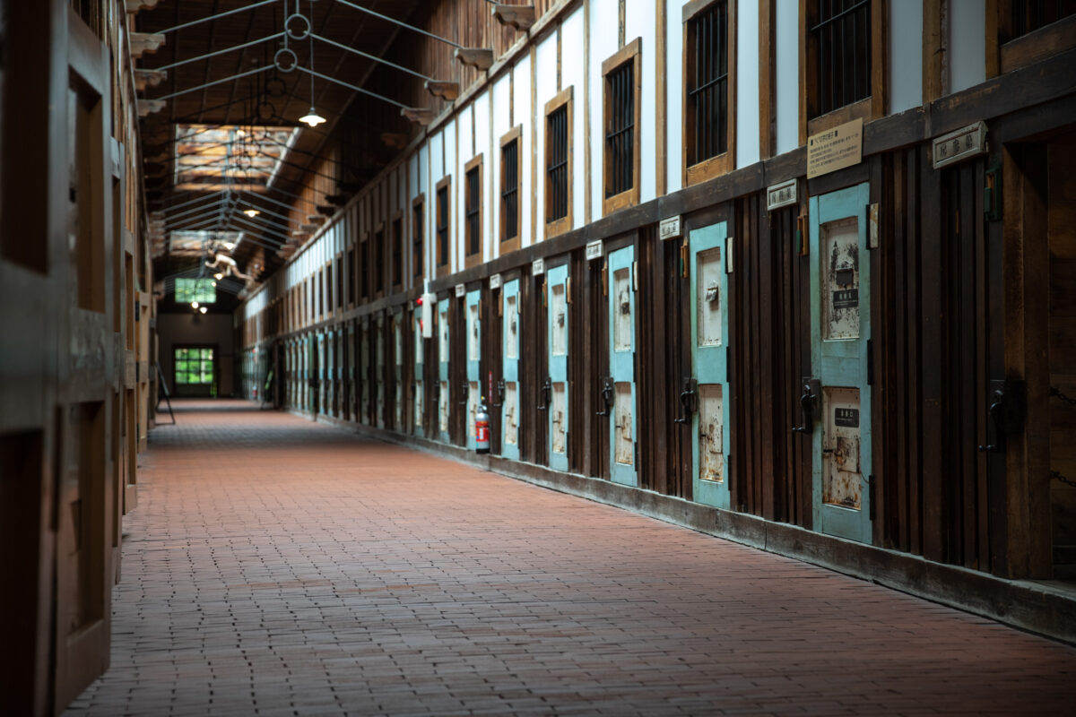 Abashiri Prison corridor in Hokkaido, Japan with rows of weathered wooden cell doors