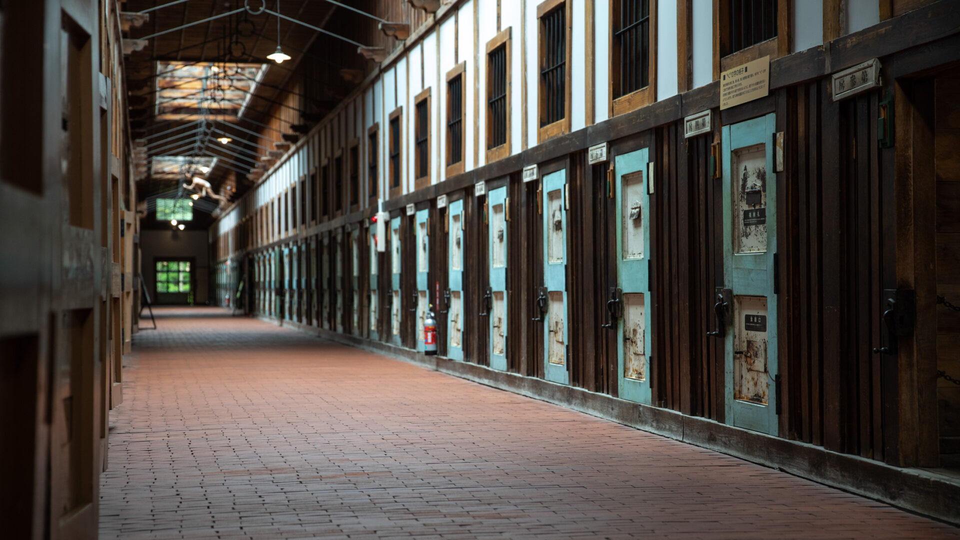 Abashiri Prison corridor in Hokkaido, Japan with rows of weathered wooden cell doors