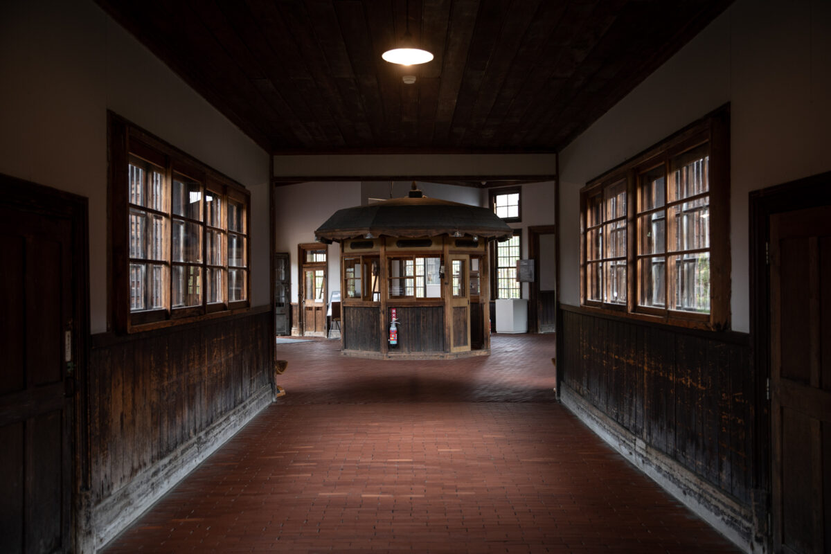 Symmetrical corridor in Abashiri Prison, Japan, with windows and central guard booth.