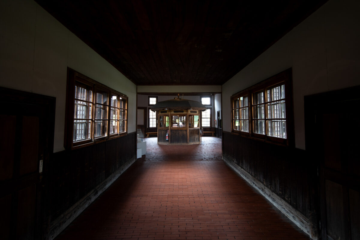 Abashiri Prison corridor with barred windows and guard station, historic Japanese prison interior