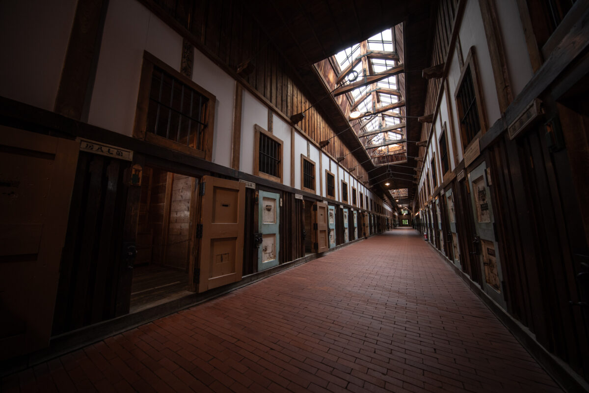 Abashiri Prison interior corridor with wooden cell doors and skylights, Japan