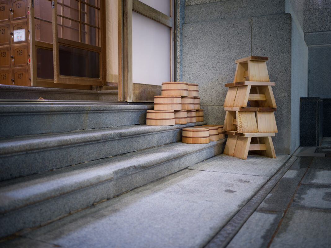 Stacked wooden wash basins and stools on stone steps at Dogo Onsen, Japan