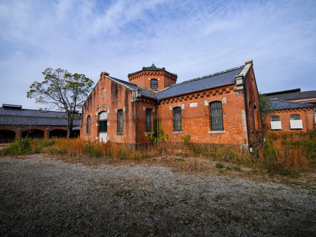 Historic red-brick Nara Prison facade in Japan with octagonal tower and barred windows.