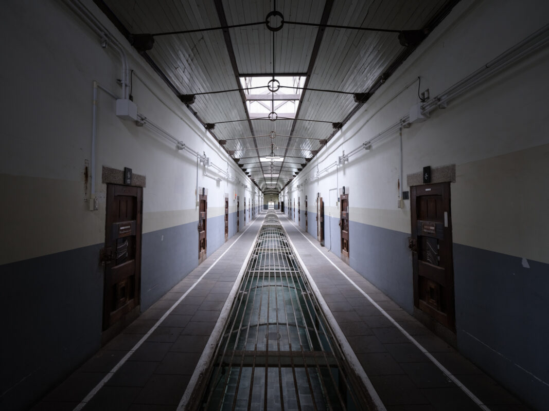 Symmetrical cellblock corridor in historic Nara Prison, lined with doors under skylights.