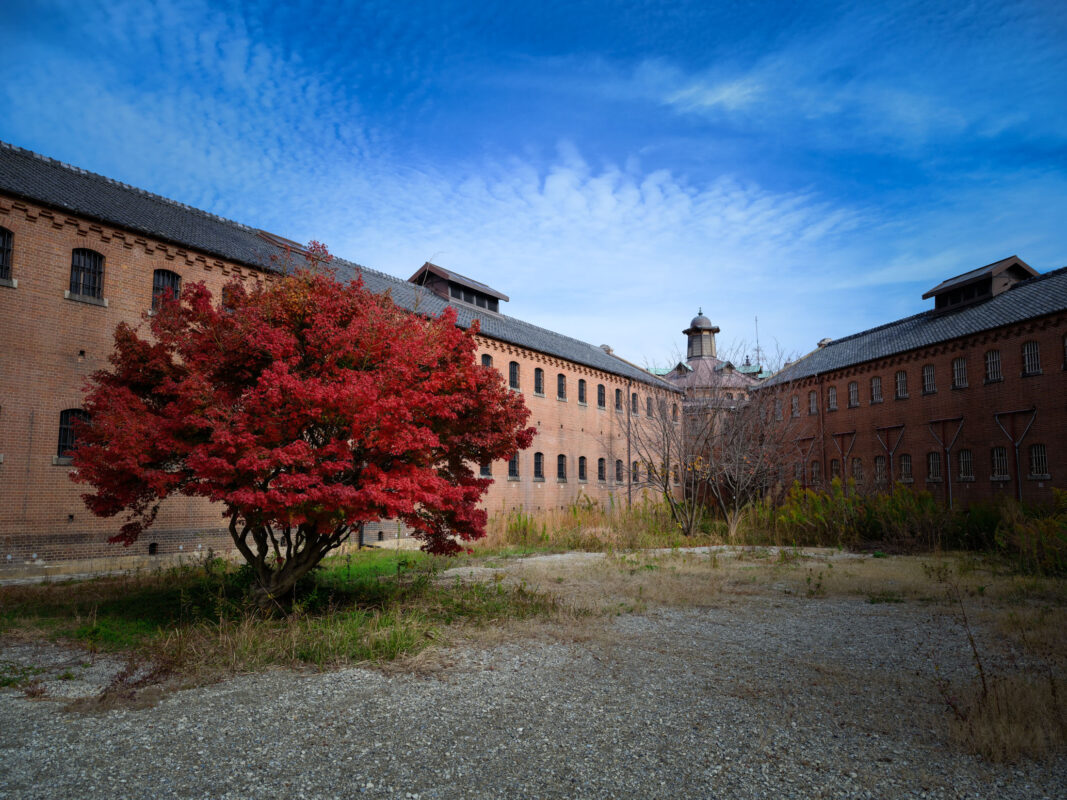 Autumn courtyard at historic Nara Prison in Japan, red brick buildings and watchtower
