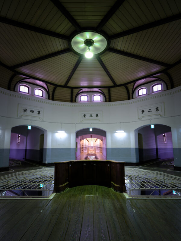 Interior of Nara Prison central hall with domed ceiling, guard post, and cell doors