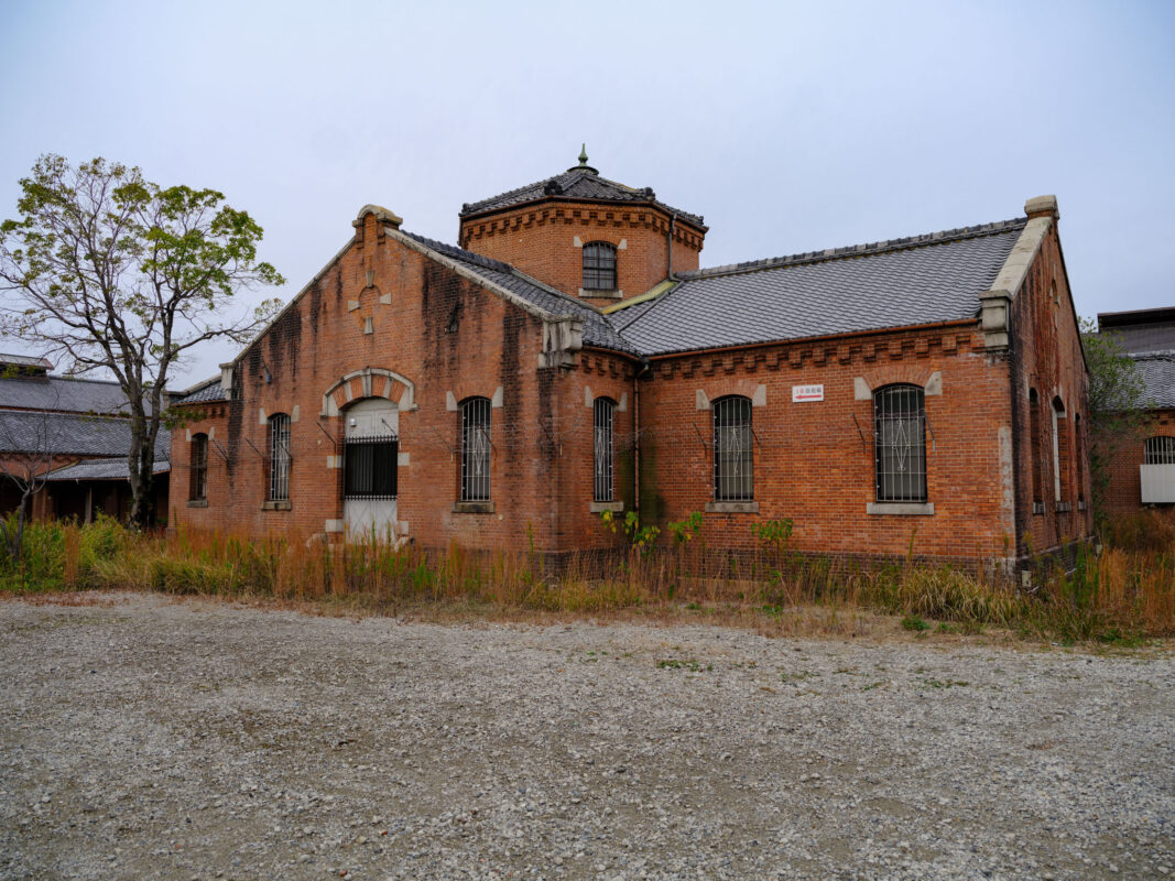 Historic red-brick Nara Prison in Japan with barred windows and central watchtower