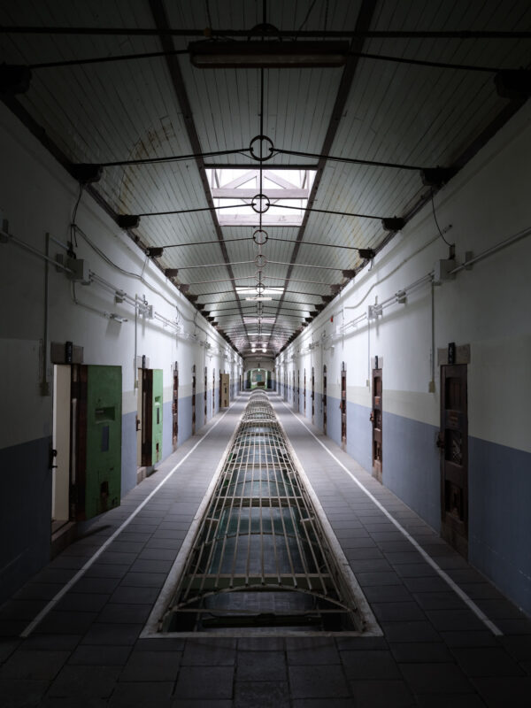 Empty corridor inside Nara Prison with arched skylights and rows of cell doors