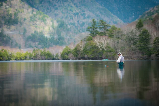 Grey-blue waters gleam, Whispering mountains cradle, Peaceful cast away.---灰青の水 囁く山に抱かれ 穏やかな投げ---#offbeatjapan #japan #naturalmagic #serenescape #japanesemountains #fishinglife #quietmoments #naturetherapy