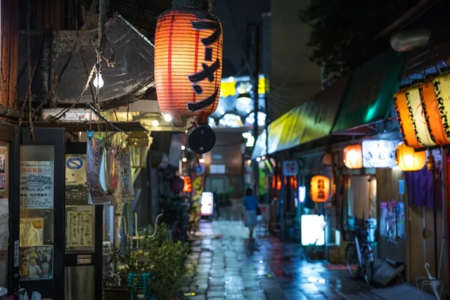 Lanterns softly glow, Slate-gray mirrors vibrant hues— City whispers dreams.---ランタンの灯り、 石畳に映る— 街の夢語。---#offbeatjapan #japan #japanesenightlife #yokocho #neonnights #lanterns #urbanjapan