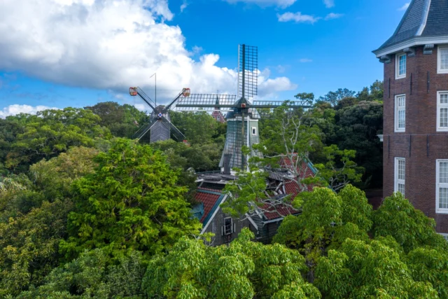 In whispers of green, A windmill twirls tales untold, Red roofs fade in time. 静かな緑の中で、 風車が語らぬ物語を回し、 赤い屋根が時と共に消えていく。#windmilltales #rusticcharm #natureandcity #urbanserenity #japancontrast #offbeatjapan #japan