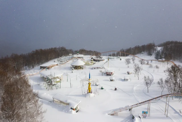 Snow coats silenced rides, Colors muted, dreamland sleeps— Winter's whispered hush.冬の儚夢 色の音、降る雪— 静寂の調べ#snowysilence #winterwonder #japansnow #forgottenfair #wintermagic #amusementpark #offbeatjapan #japan